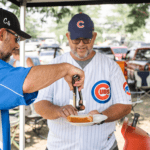 Retirement Planner Chawn Honkomp serving a hot dog at last year's tailgate at Principal Park in Des Moines