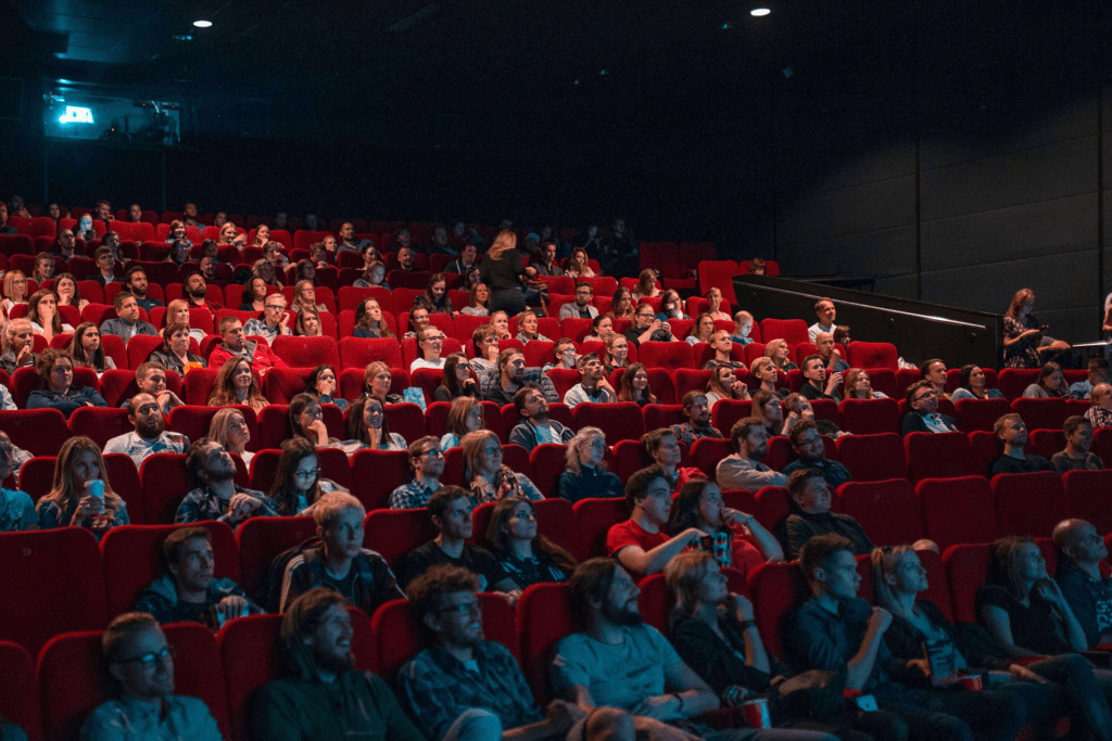 Movie theater full of people watching and eating popcorn