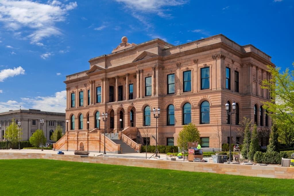 Photo of the World Food Prize building in Des Moines, Iowa with blue sky and green grass