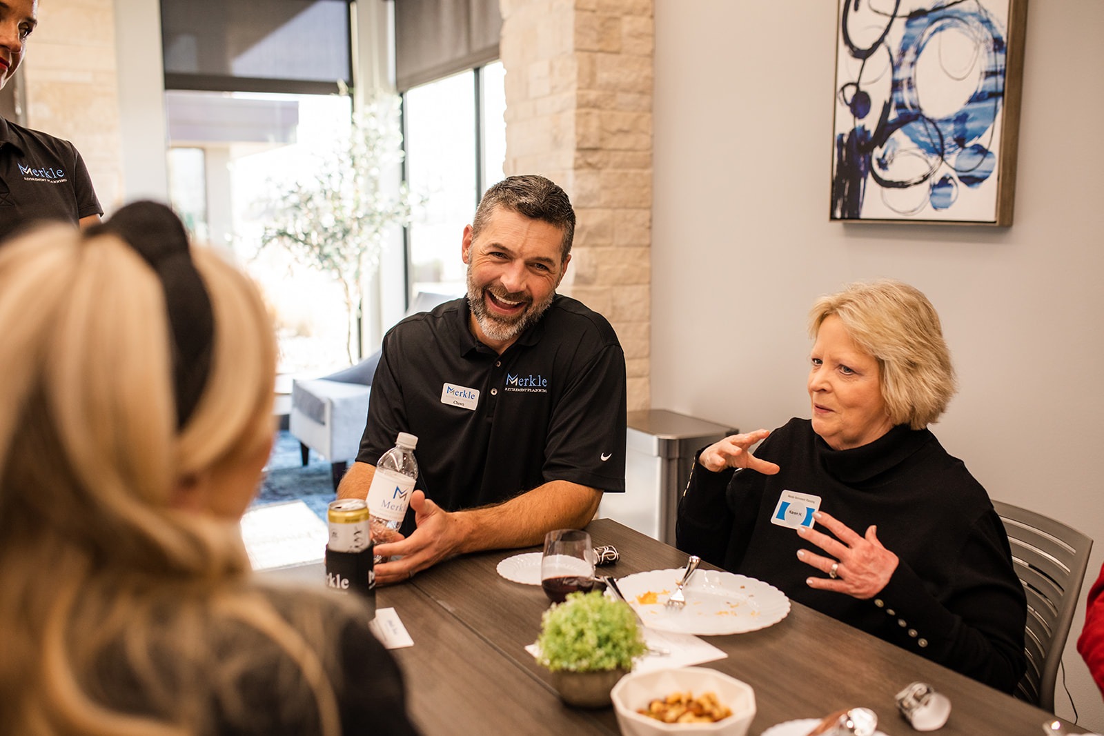 Man speaking to two women. All laughing.