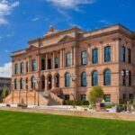 Photo of the World Food Prize building in Des Moines, Iowa with blue sky and green grass