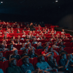 Movie theater full of people watching and eating popcorn