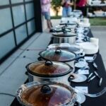 Lined up crockpots of chili soup outside during a tailgate